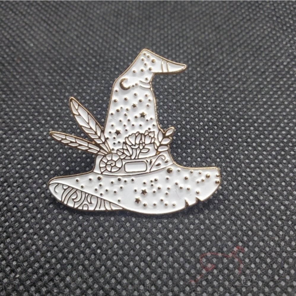 witches hat enamel pin. White with gold backing.